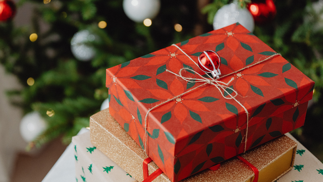 An image of Christmas presents in front of the tree